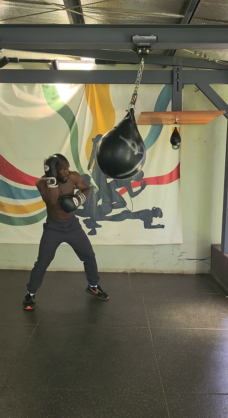 Tim in his boxing stance in front of the mural