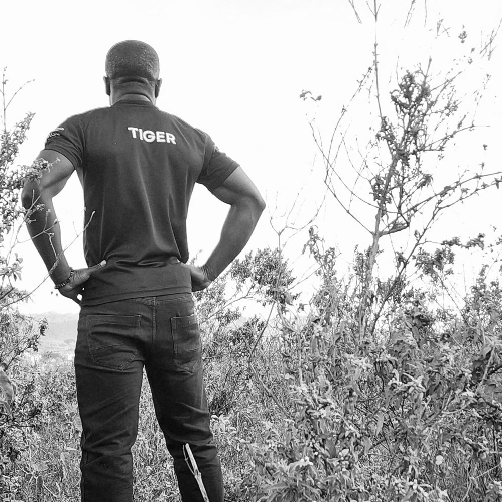 Tim on a hill in his Tiger shirt, looking at the view