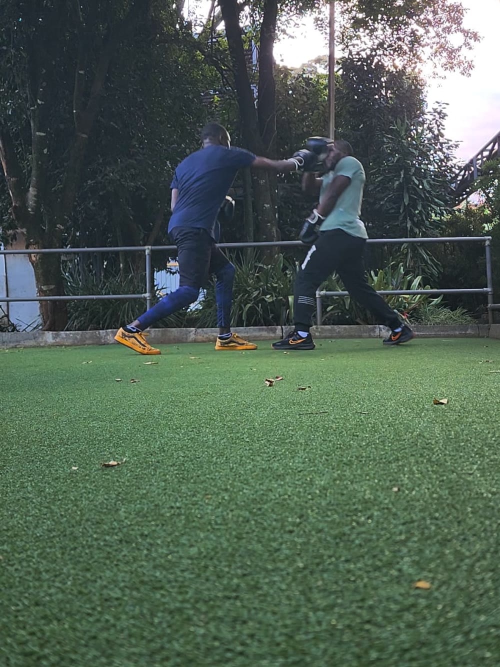 A client driving a punch into the pad Tim is holding